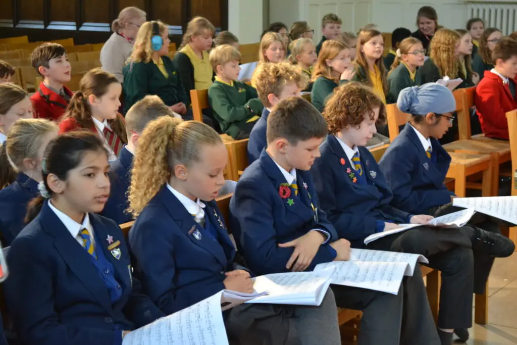 Rows of pupils singing songs with their lyrics sheets in front of them.