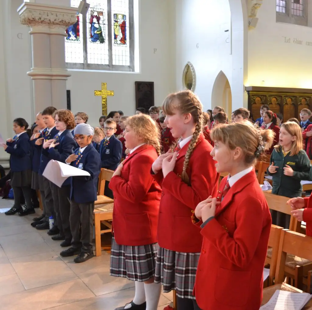 Pupils from various schools standing up to sing and perform songs.