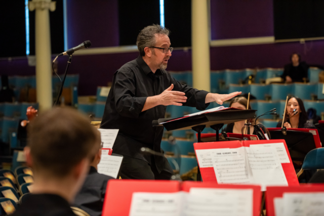 Mr Parrans-Smith conducting a school orchestra.