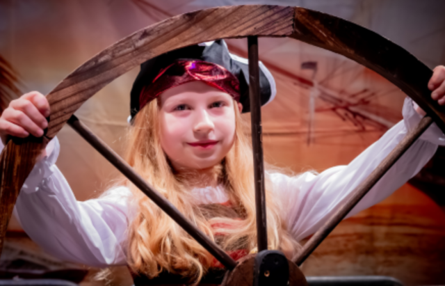 A young female pupil dressed as a pirate performing a show.